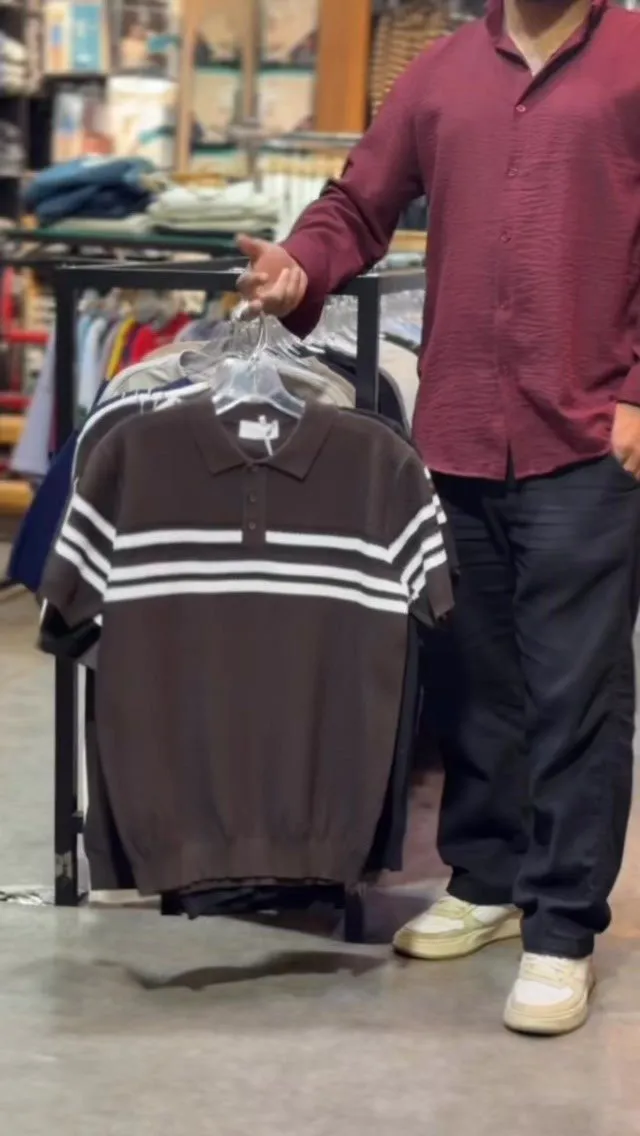 Brown knit polo with white chest stripes on a rail in the KL14 store