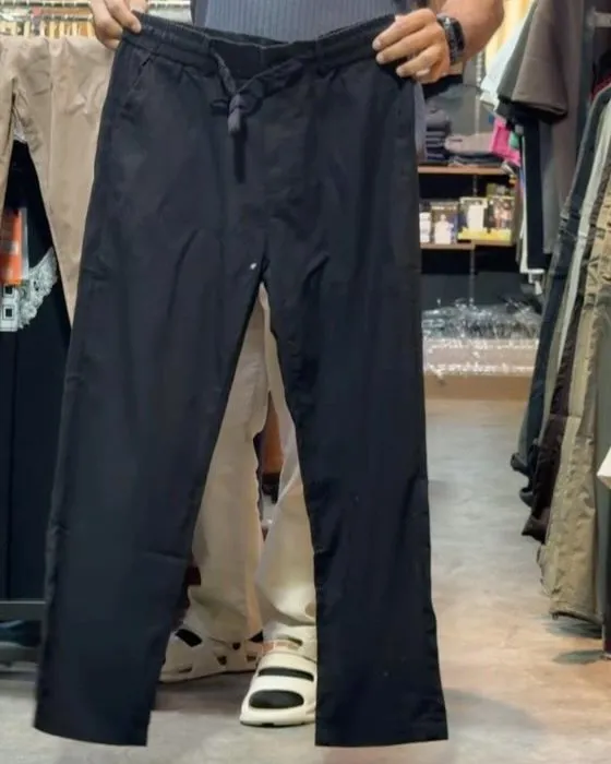 Close-up of the drawstring waist on the black linen trousers